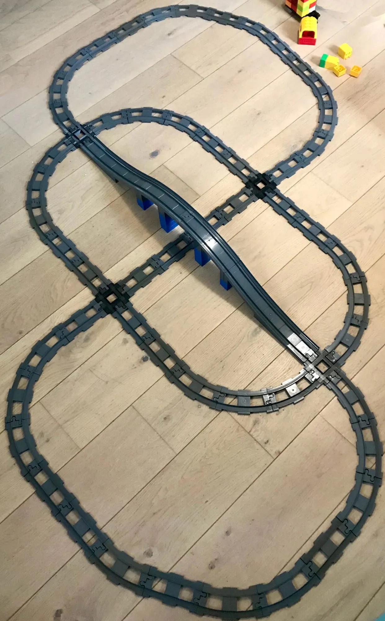 Circuit de rails DUPLO en forme de huit avec un croisement 4 voies noir, vu de dessus