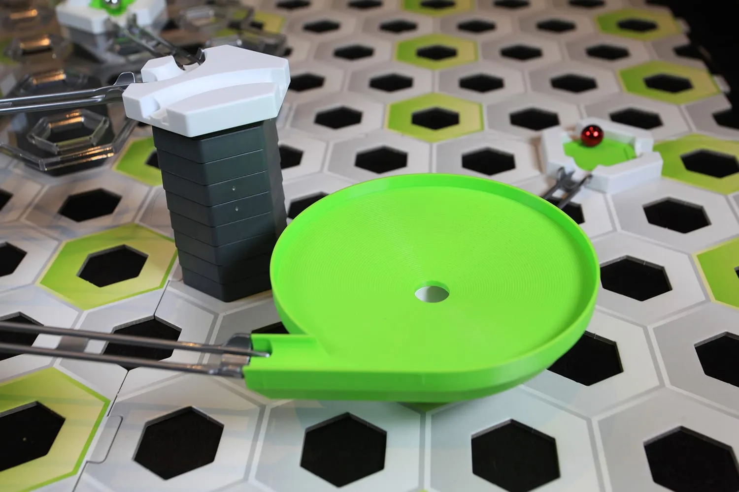 Méga toupie verte dans un circuit GraviTrax, une bille rouge en haut à droite