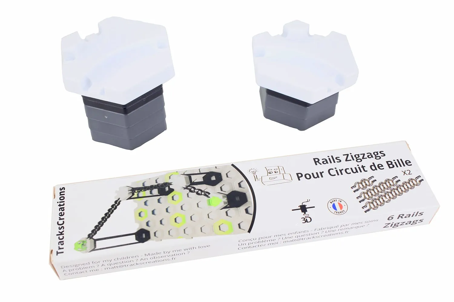 Boîte TracksCreations « Rails Zigzags » devant deux tours GraviTrax