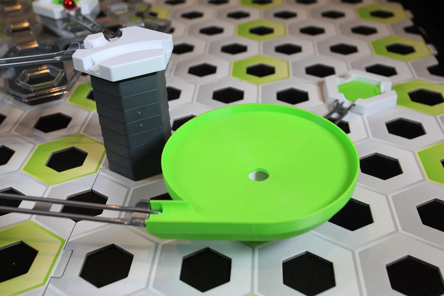 Méga toupie verte intégrée à un circuit GraviTrax à côté d’une tour grise