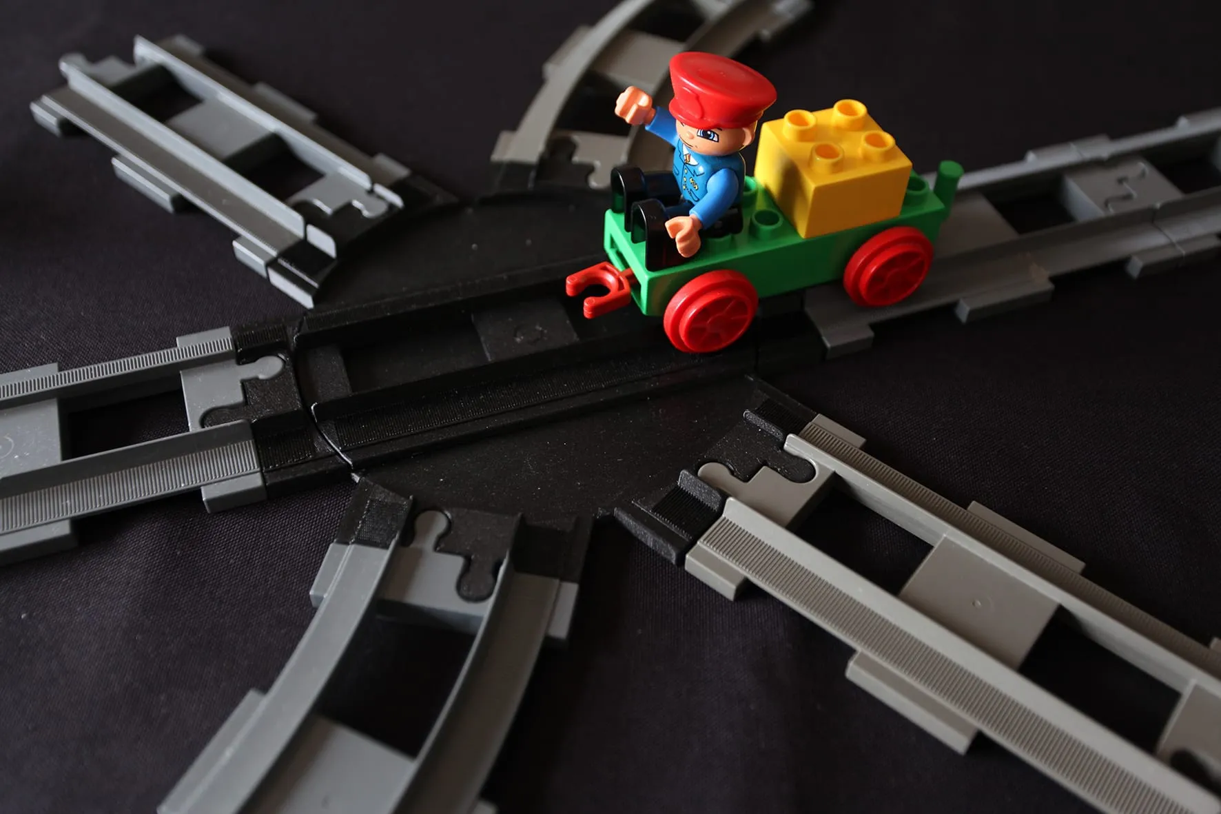 Train DUPLO vert avec son conducteur sur le croisement rotatif entouré de rails DUPLO