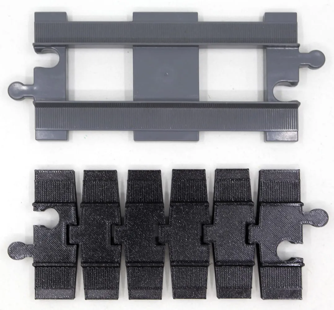Rail droit DUPLO gris au-dessus d’un rail flexible noir de même longueur