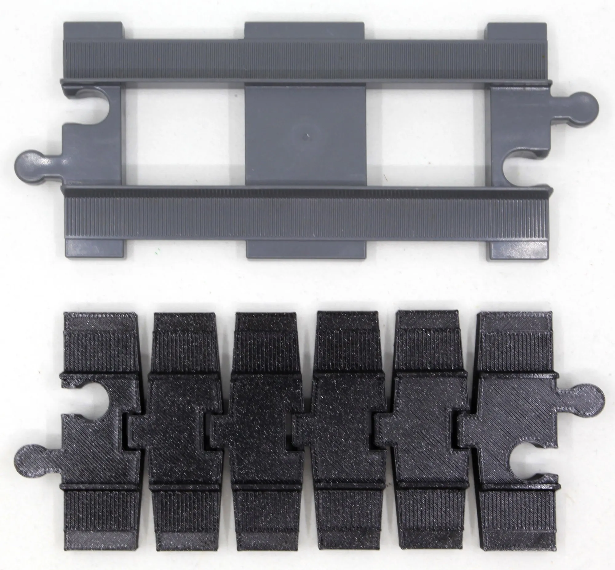 Rail droit DUPLO gris au-dessus d’un rail flexible noir de même longueur