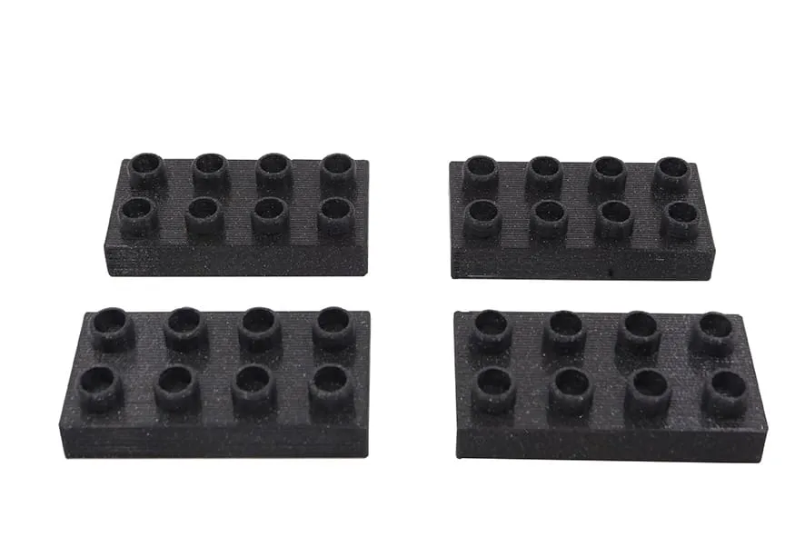 Quatre briques penchées noires compatibles DUPLO, vues de dessus