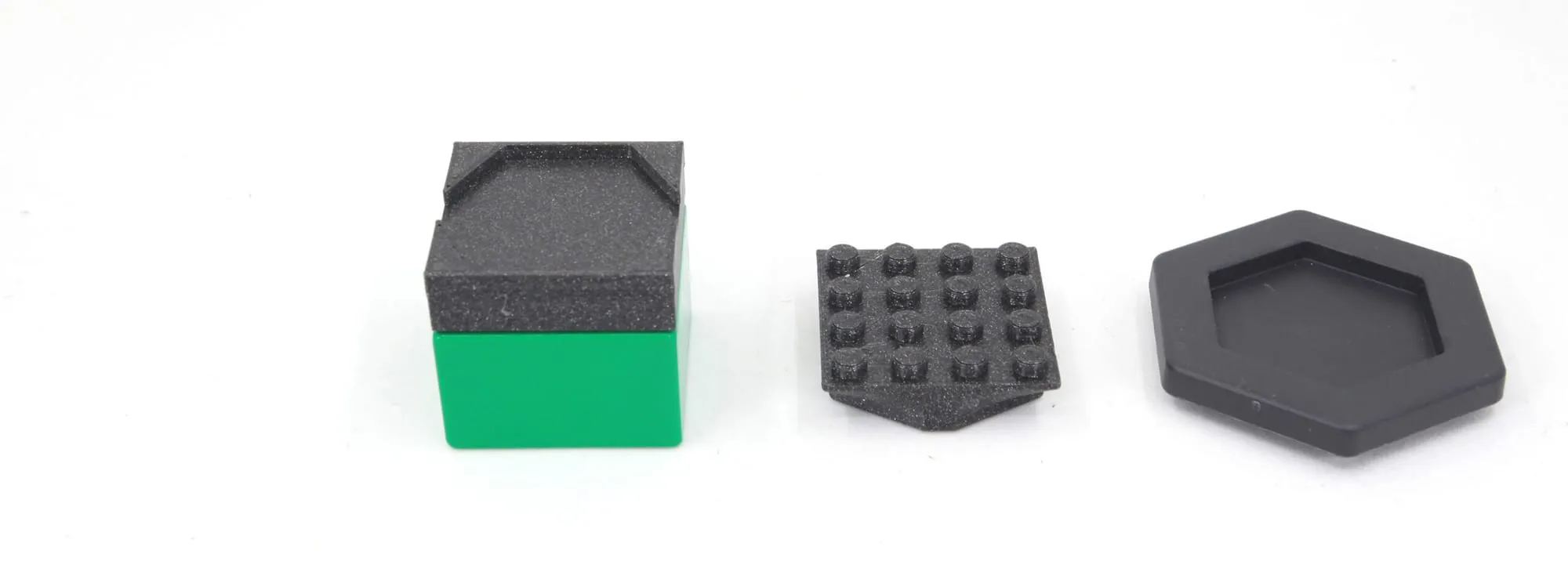 Adaptateur sur une brique DUPLO verte, adaptateur à plots et adaptateur hexagonal noirs alignés
