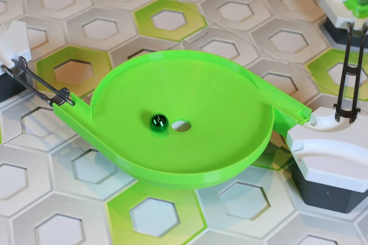 Toupie escargot verte compatible GraviTrax posée sur un circuit